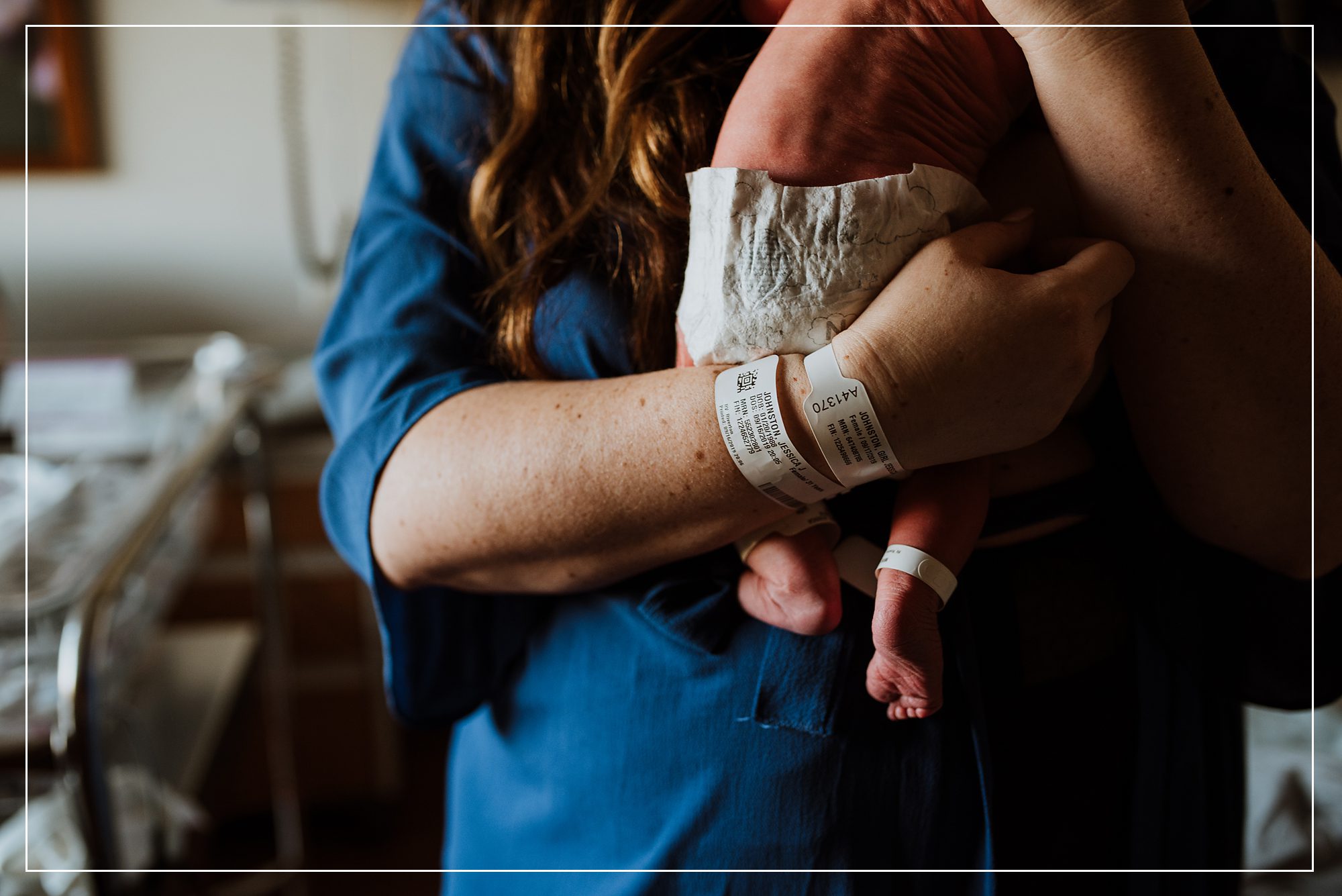 Newborn baby being held by mother, both wearing hospital bracelets, captured in a tender Fresh 48 session in Utah.