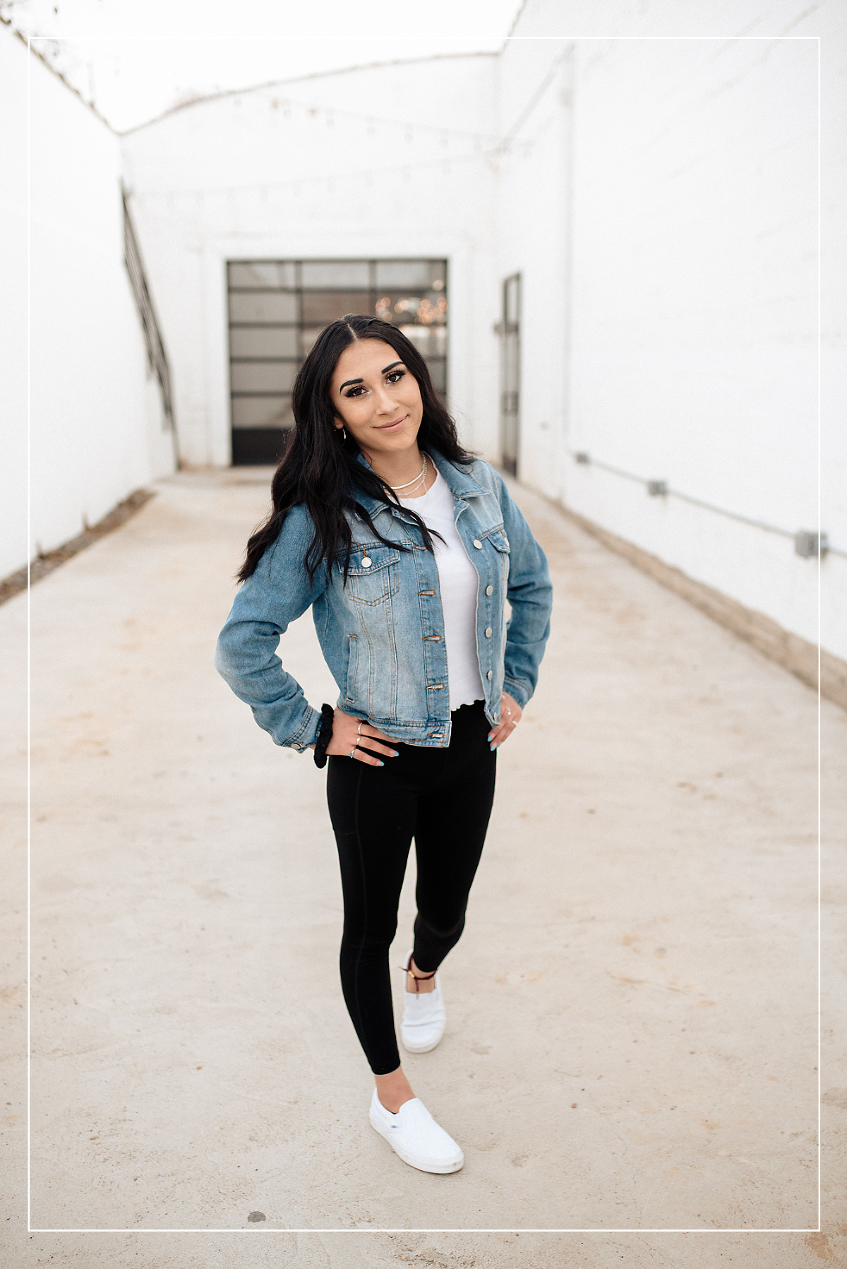High school senior in a denim jacket posing confidently for a senior photo session in Utah, with a modern and urban backdrop.