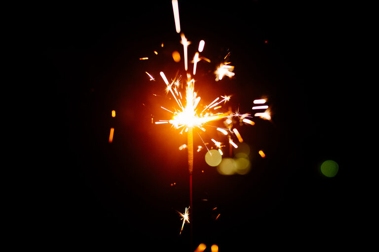 A lit sparkler firework at night. Learn to write with sparklers & photograph it!  