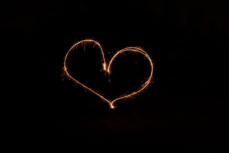Writing with a sparkler in the shape of a heart 