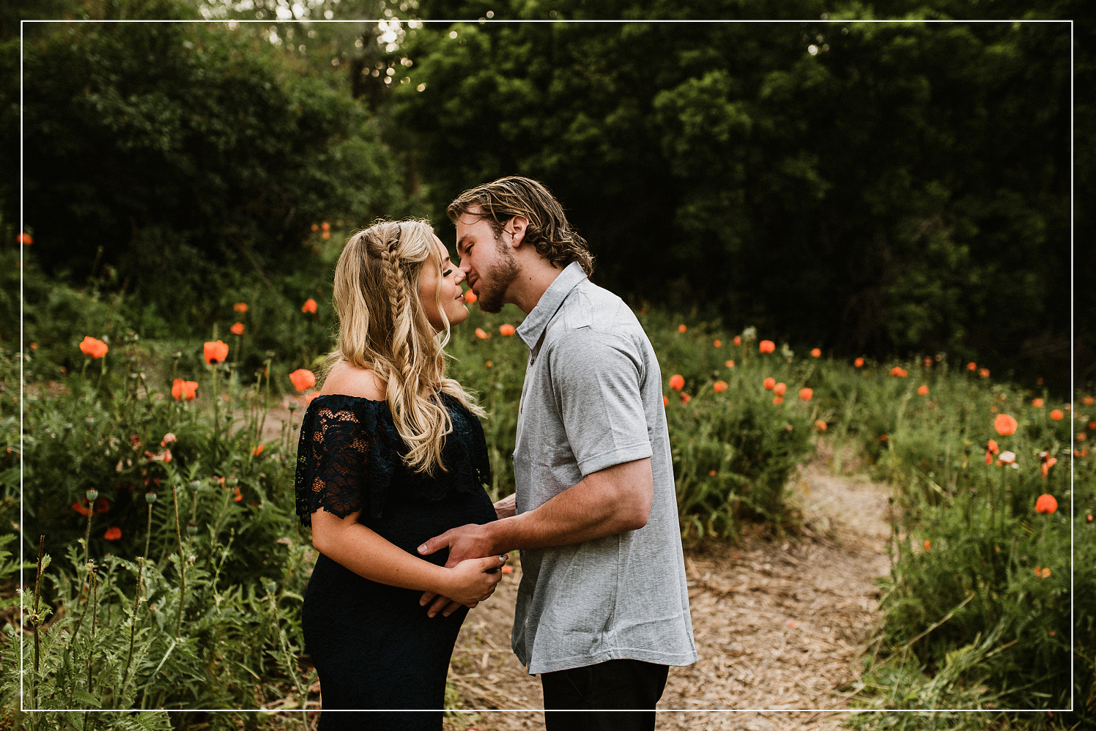 Pregnant couple sharing an intimate moment in a poppy field during a maternity photo session in Utah, capturing love and anticipation.