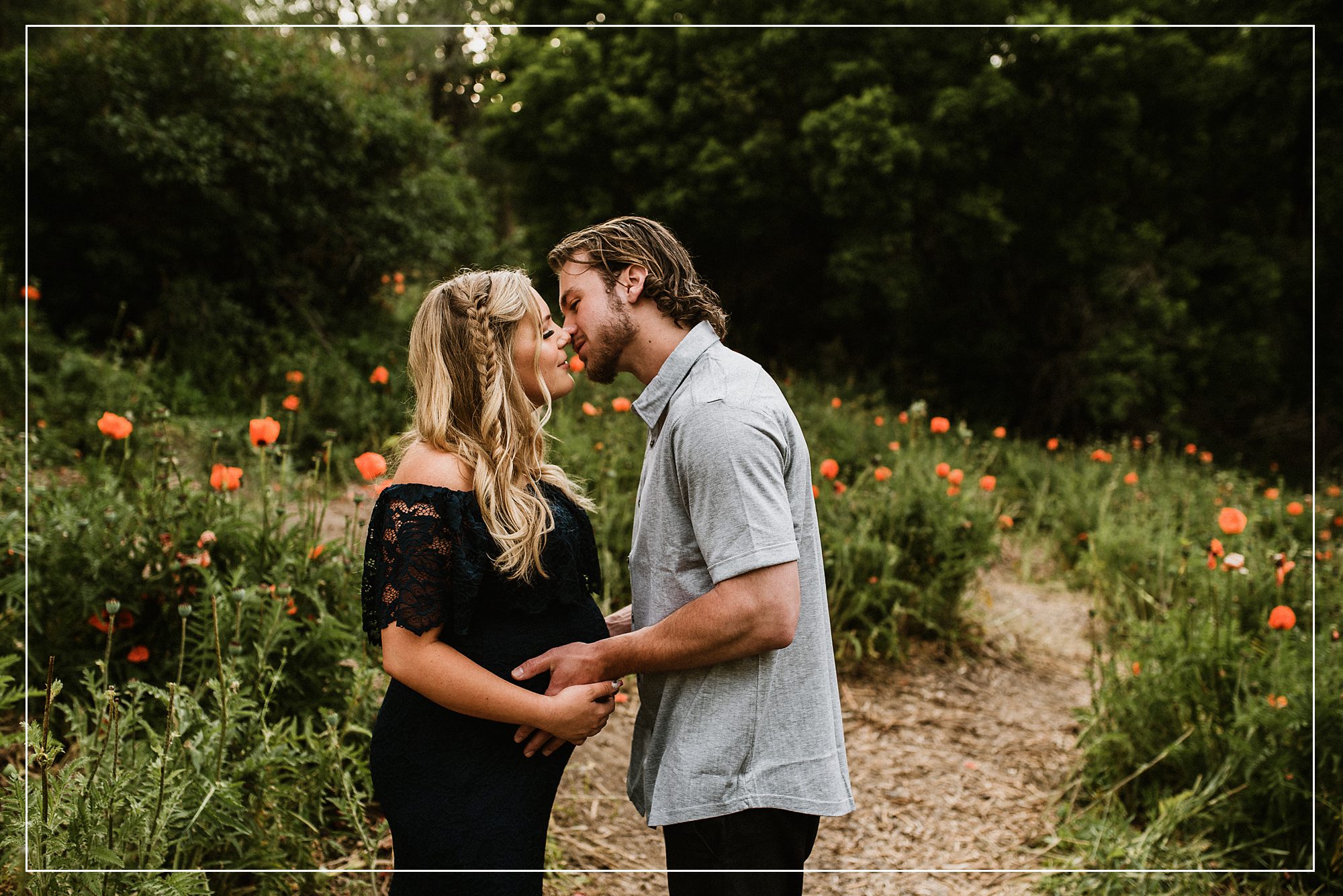 Pregnant couple sharing an intimate moment in a poppy field during a maternity photo session in Utah, capturing love and anticipation.